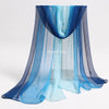 A sheer blue and gray fabric scarf draped over a clear window, used for sensory play.