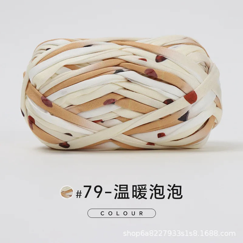 A ball of hand-dyed fabric strip yarn in beige and brown tones, used for crochet and knitting.