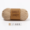 A skein of beige hand-dyed fabric strip yarn labeled Sweet Candy Yarns.