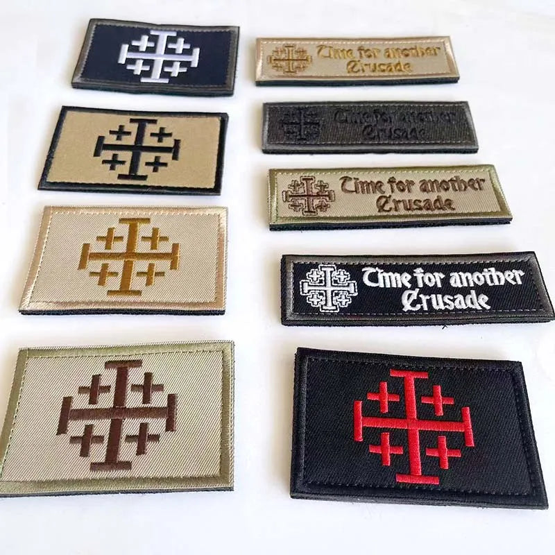 A collection of embroidered patches featuring a cross design and text related to Crusades morale.