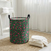 A green and pink leopard print foldable laundry basket sitting on a woven rug near a window.