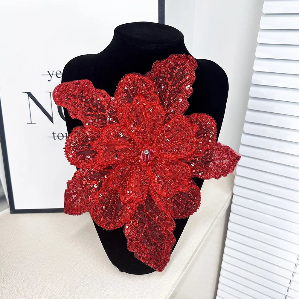 A vibrant red 3D floral fabric applique patch made of sequin lace displayed on a black mannequin.