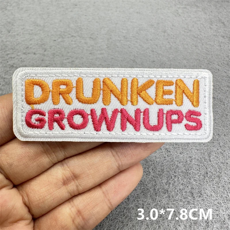 White embroidered patch with orange text reading DRUNKEN GROWNUPS