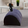 A purple and black inflatable body support pillow resting on a gray surface.