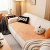 A white sofa features an orange flannel pad cover with a black pillow and a white pumpkin decoration.