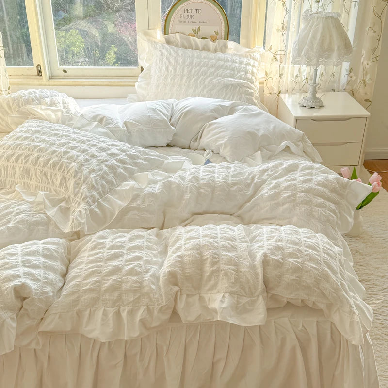 White lace seersucker duvet cover set displayed on a bed with natural light and floral decor.