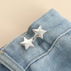 Silver star-shaped button clips attached to a blue denim fabric