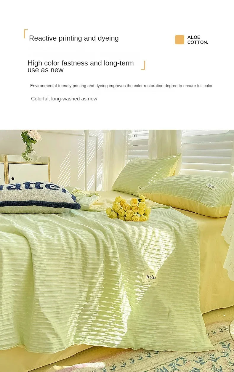 A light green Korean style seersucker summer quilt set with white stripes displayed on a bed.
