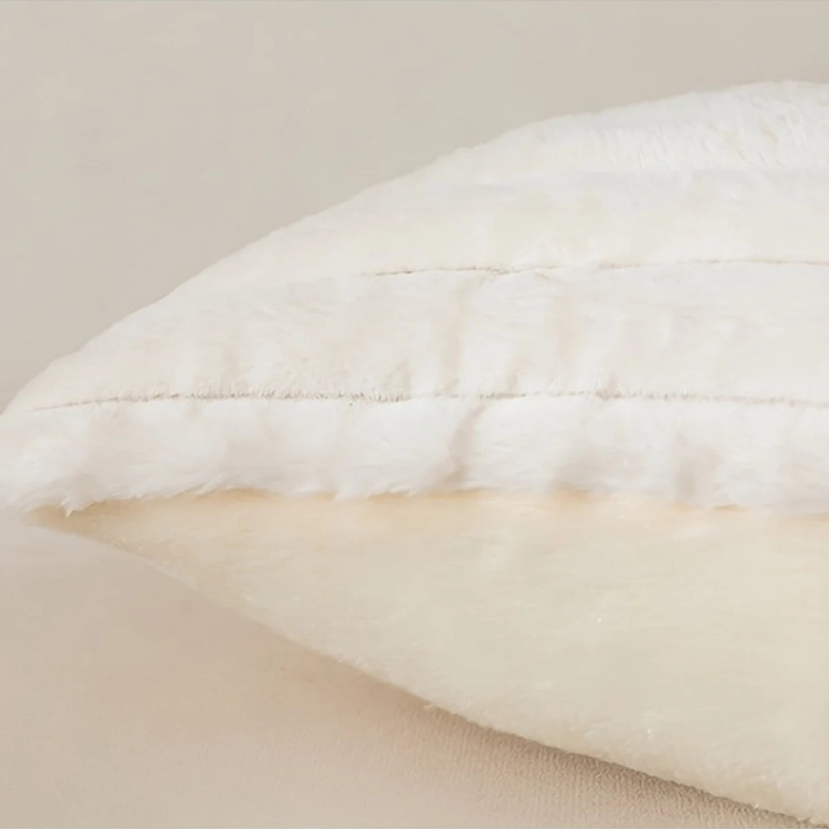 A close-up view of a white plush decorative pillowcase with subtle stripes and a visible seam.