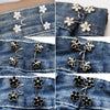 Silver and gold floral alloy button clips used for adjusting the waist of denim jeans