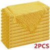 A stack of two golden yellow decorative cloth napkins with fringed edges.