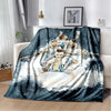 A dark blue and white blanket featuring a collage of football players in jerseys, draped over a sofa.