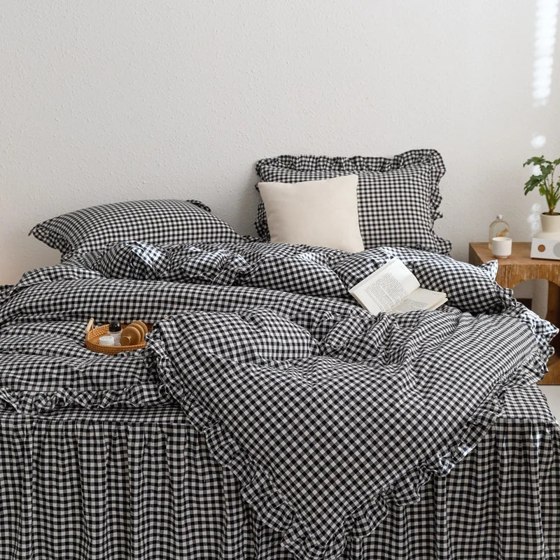 A black and white plaid duvet cover set with ruffled edges is displayed on a bed.
