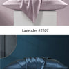 A lavender silk pillowcase draped elegantly on a white stand, next to a navy blue silk pillowcase.
