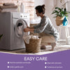 A woman is using a washing machine to clean a white pillow protector cover, demonstrating easy care features.
