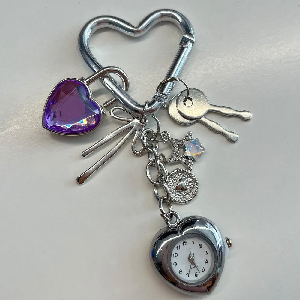 Silver keychain featuring a heart charm, a key, and a pocket watch.