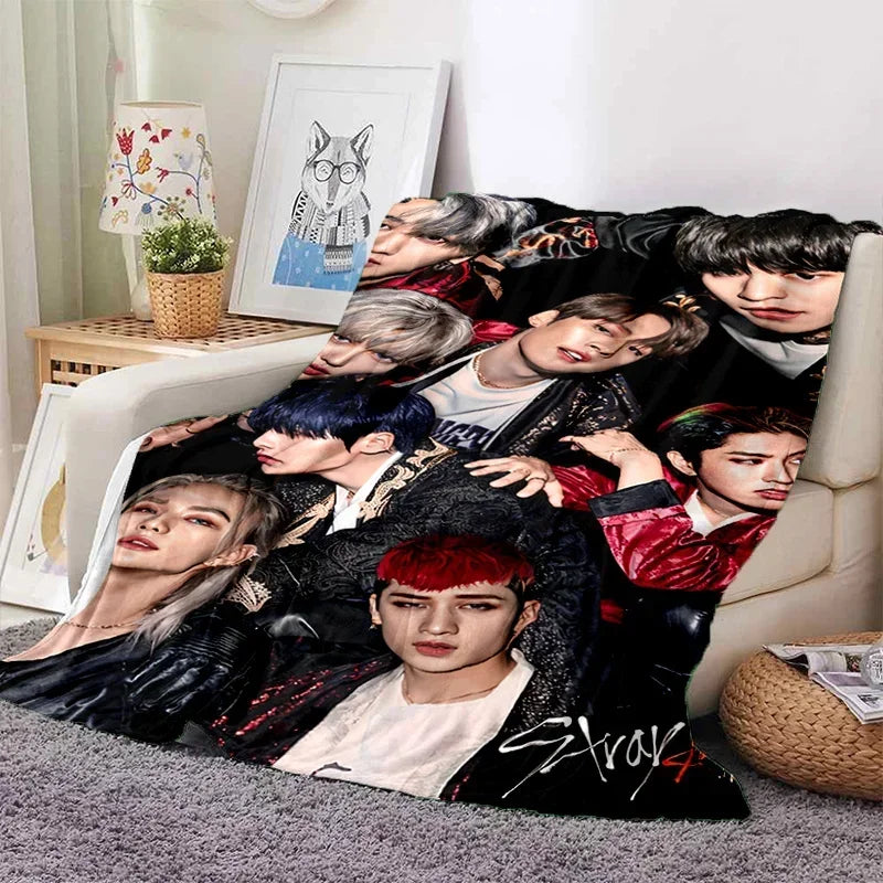 A collage of multiple Stray Kids members in various poses and outfits printed on a fleece throw blanket.