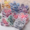 Assortment of prewound sewing machine bobbin threads in various colors and sizes packaged in clear plastic containers.