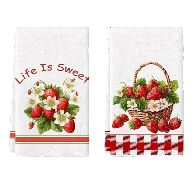 A set of two white kitchen towels featuring a red strawberry floral design and a checkered border.