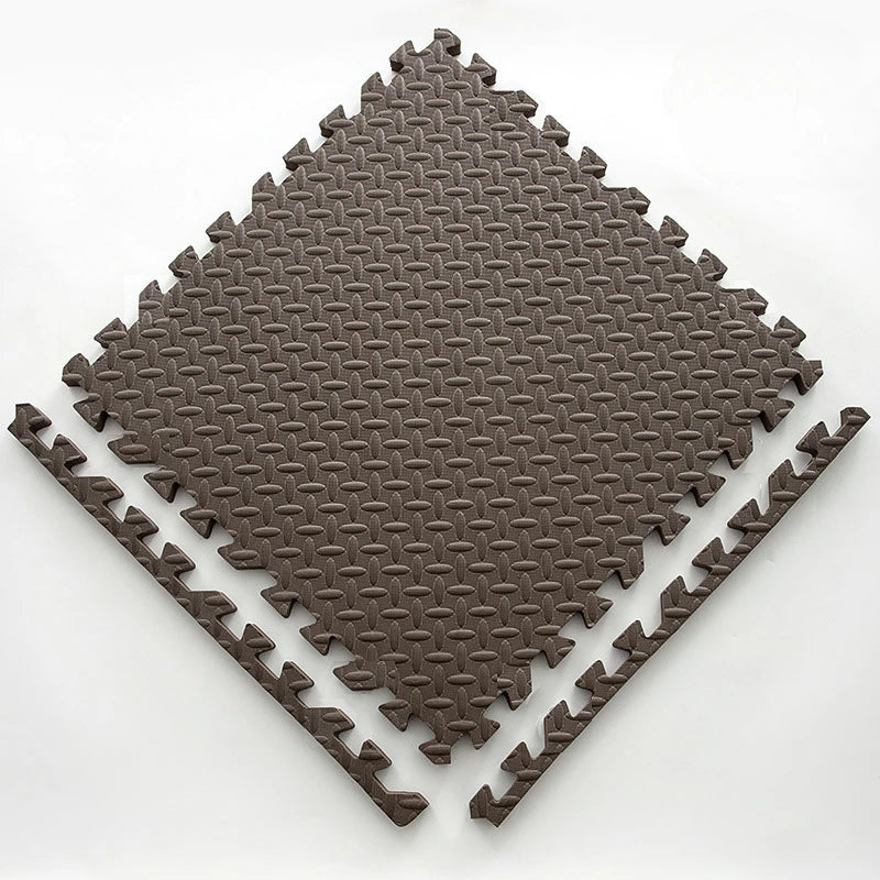 A dark brown interlocking foam play mat with a diamond pattern, shown from above.