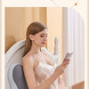 A woman is relaxing while holding a phone, demonstrating the multifunctional bed snuggle pillow.