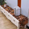 A rustic farmhouse maple leaf table runner displayed on a white wooden sideboard.