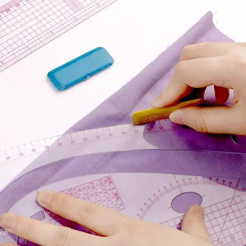A hand uses a yellow tool to mark a purple fabric with a blue plastic template and a ruler.