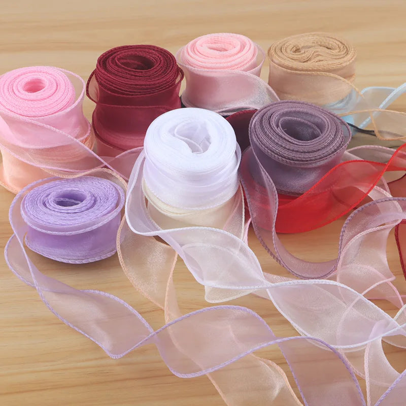 Rolls of various colored satin ribbon and sheer fabric ribbons for DIY crafting