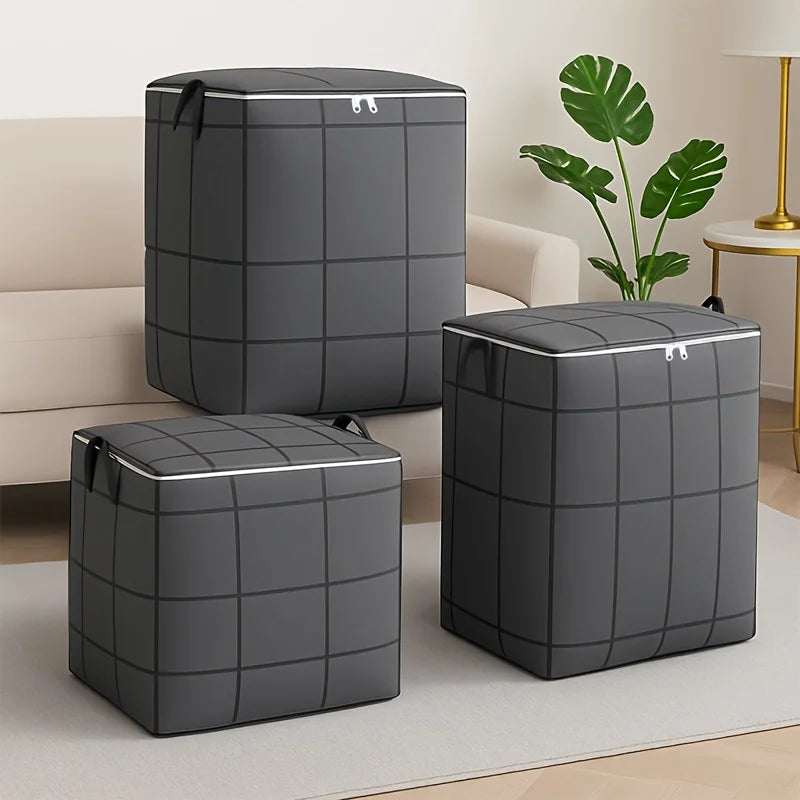 Three dark gray fabric storage bags with zippers and handles are displayed on a light surface.