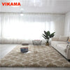 A beige geometric plush area rug placed on a light wooden floor in a bright living room.