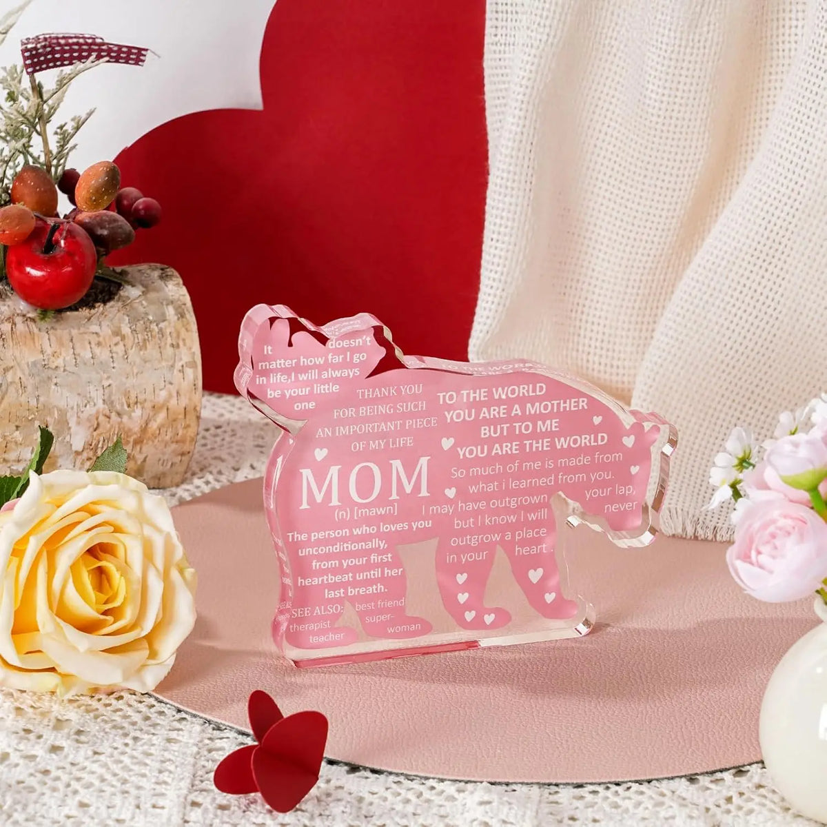 A pink personalized mom plaque keepsake resting on a pink surface with a red heart background and floral elements.