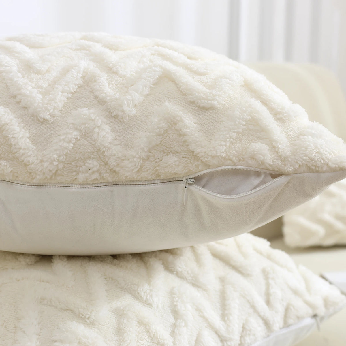 A close-up of a cream colored jacquard plush throw pillow cover with a geometric pattern.