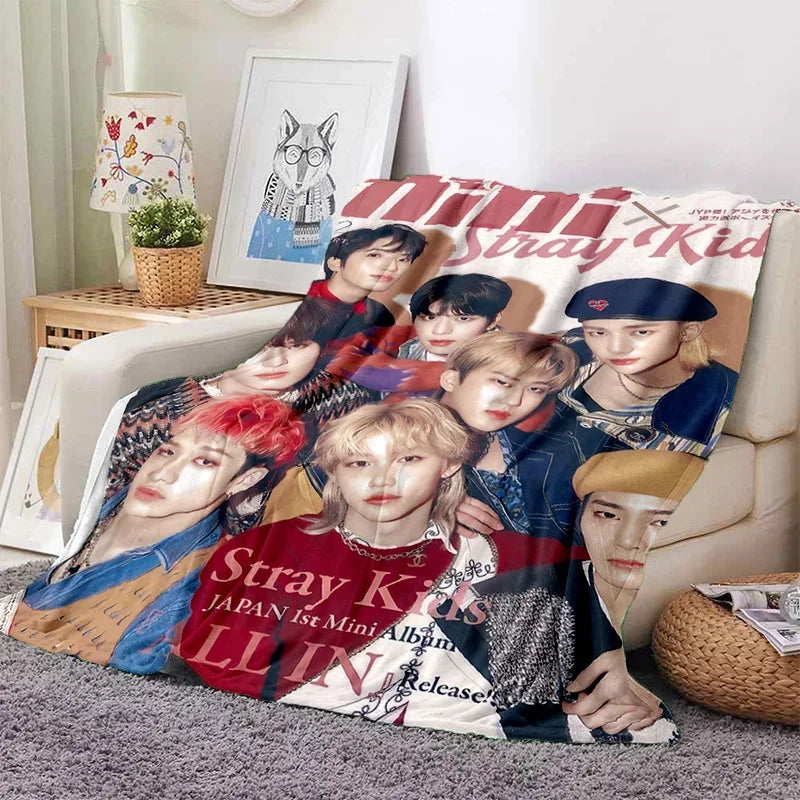 A fleece throw blanket featuring a design of Stray Kids Kpop members.