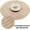 A white cup and saucer are placed on a round, beige braided placemat with clear polypropylene threads that glitter under ligh