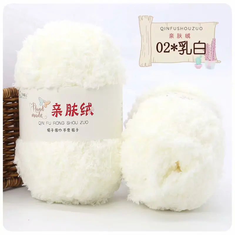 A white ball of soft coral velvet yarn labeled as QINFUSHOUZUO 02 乳白 for crafting.