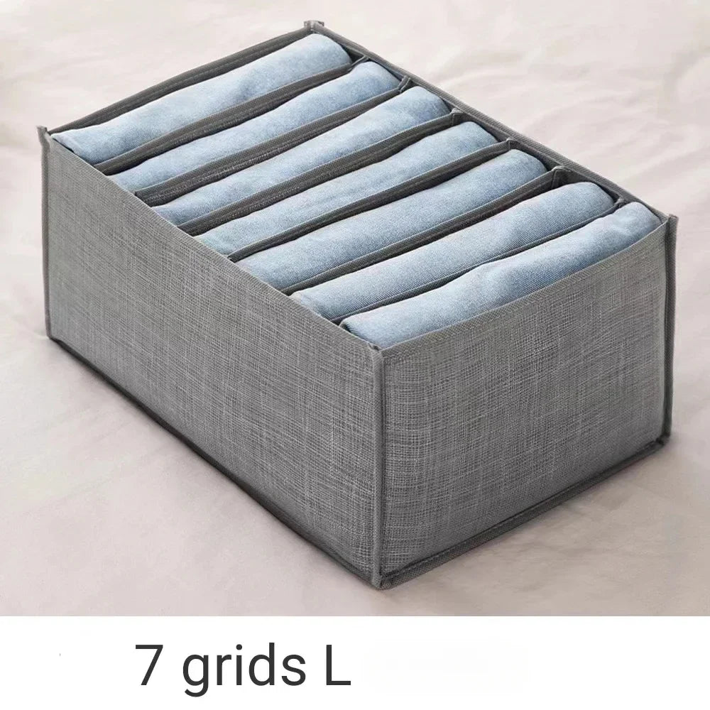 A gray foldable drawer organizer with seven fabric dividers for storing undergarments and accessories.