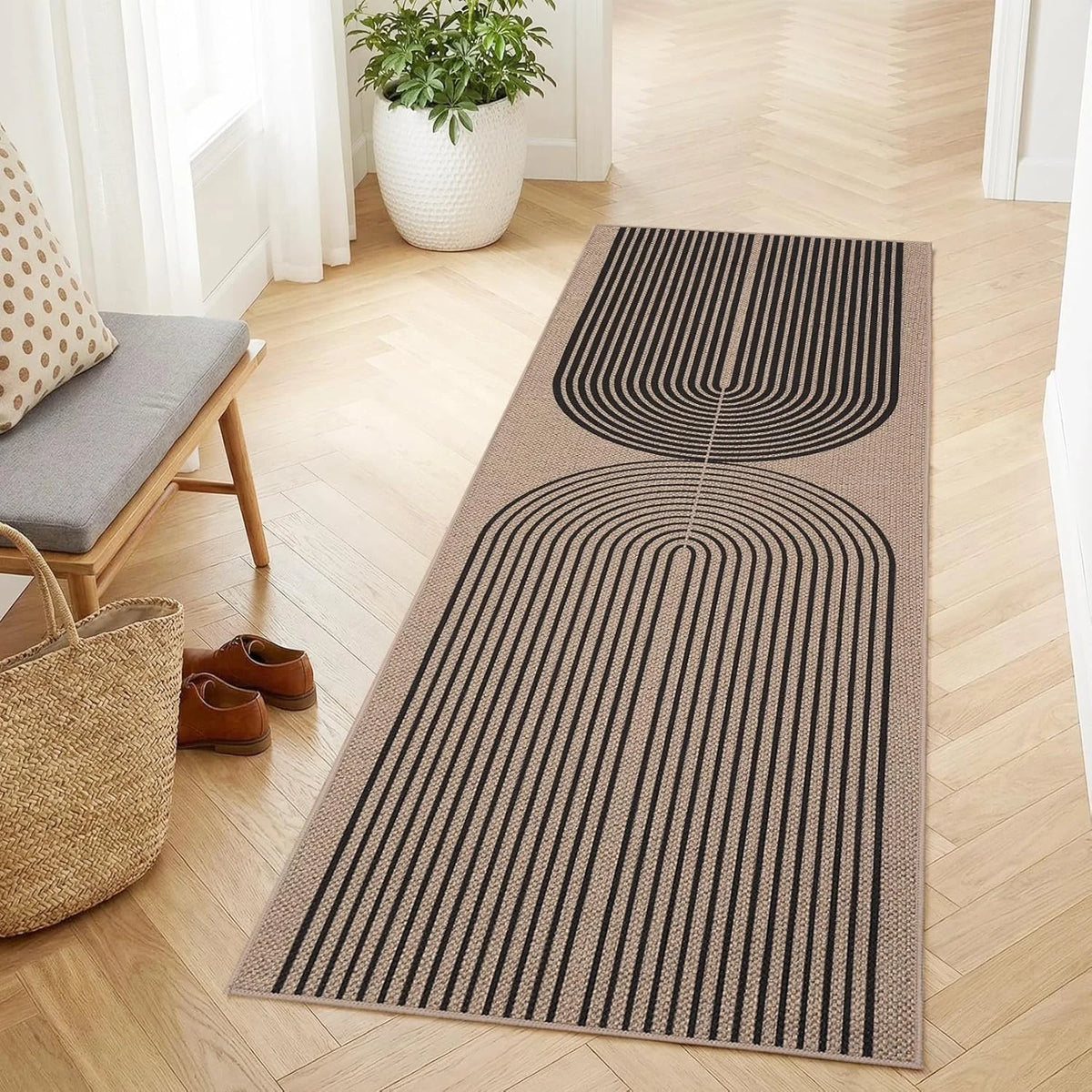 A long runner rug with black and beige geometric lines laid on a light wood floor.