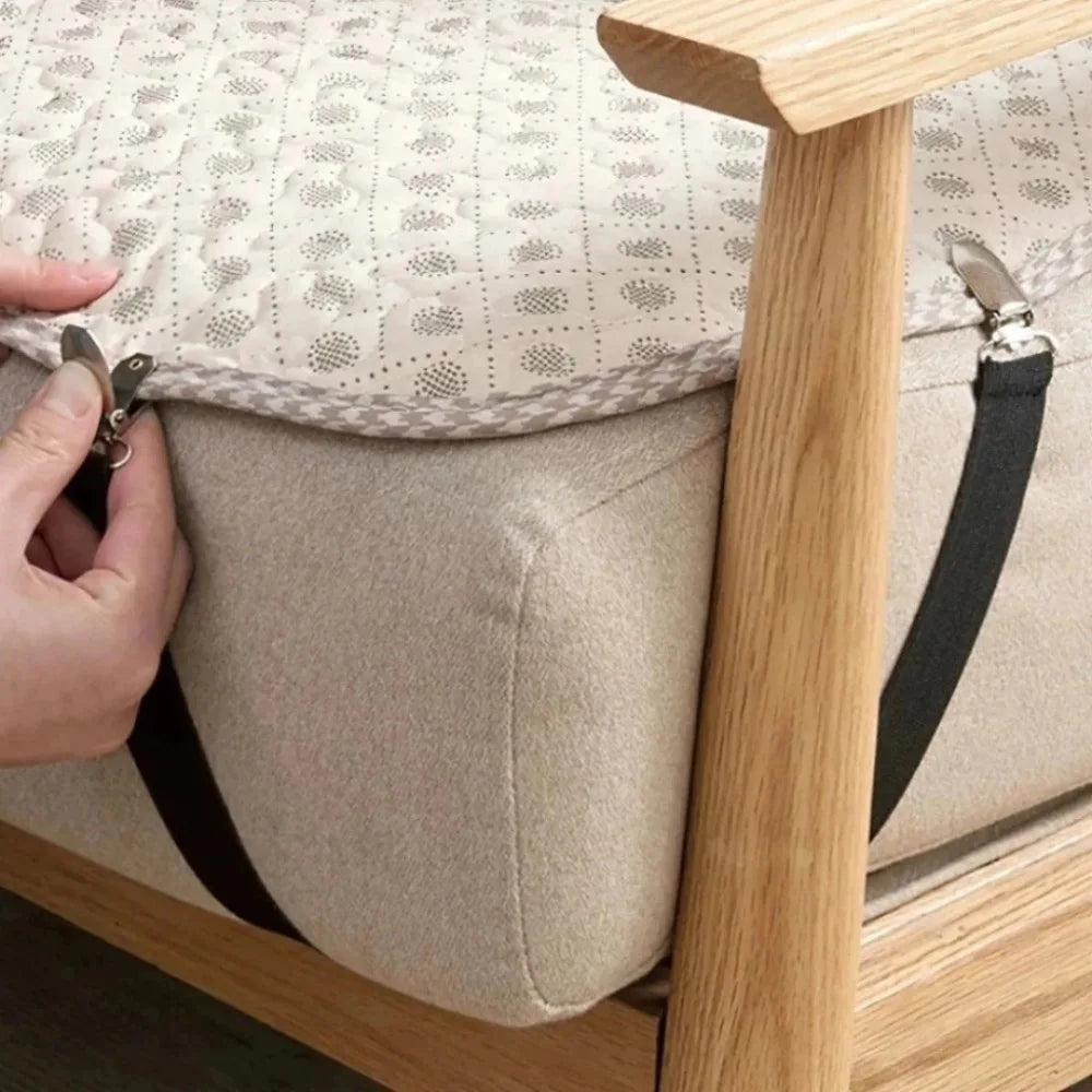 A hand is clipping a bed sheet to an adjustable triangle bed sheet clips set on a light wood bed frame.