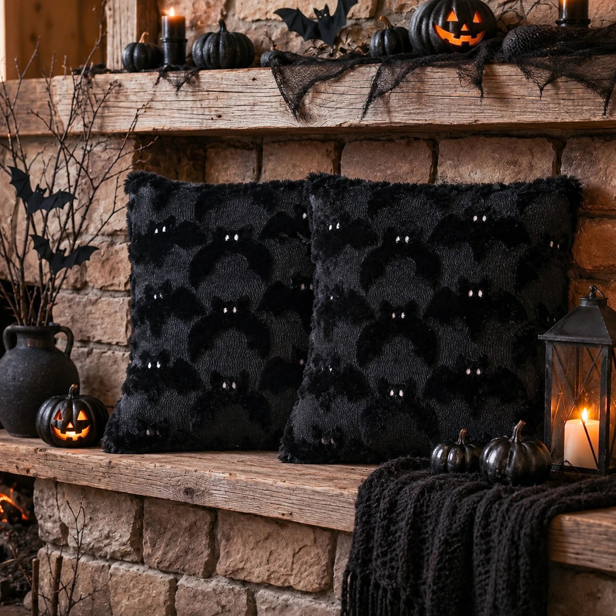 A black 3D bat plush cushion cover for Halloween decor displayed on a rustic wooden shelf with pumpkins and cobwebs.