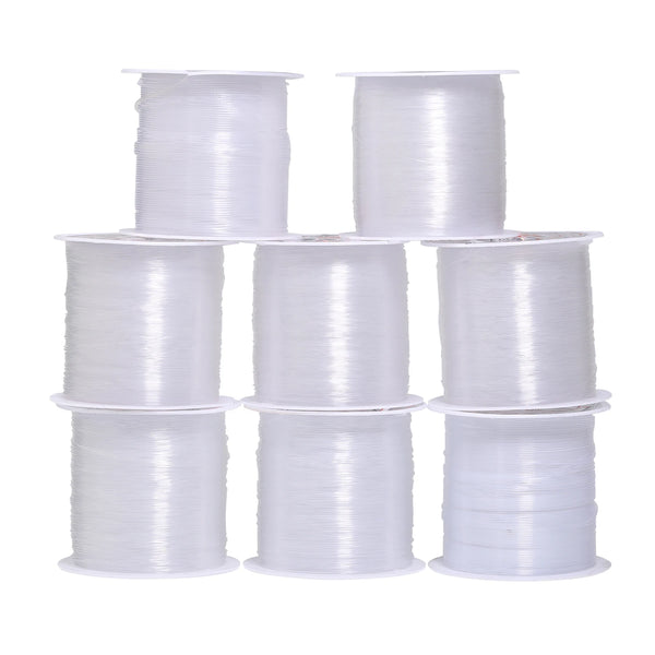 A collection of white precision nylon beading thread spools in various sizes.