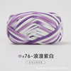 Purple and white hand-dyed fabric strip yarn coiled into a ball