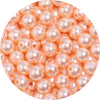 A close-up view of small, round imitation pearl beads in a pale pink color.