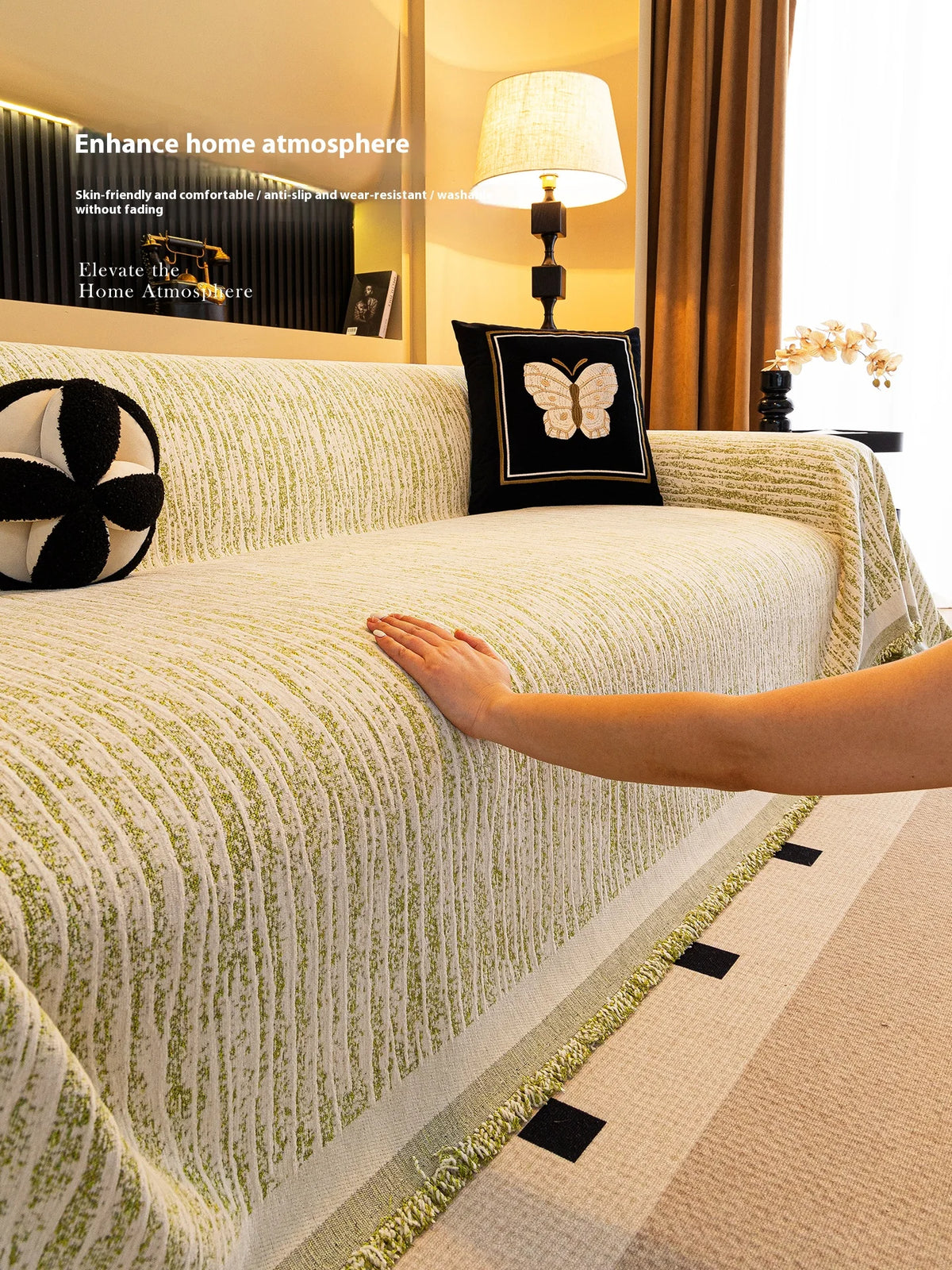 A close-up of an elegant jacquard sofa cover blanket in light green and cream tones with textured stripes.