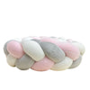 A handmade knotted floor mat for bed decor made of soft, pastel-colored wool fibers.