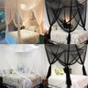 Floor-to-ceiling mosquito net curtains draped over a bed, shown in white and black fabric.