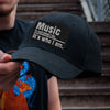 A person wearing a black baseball cap with white embroidered text that reads Music is not what I do it's who I am.