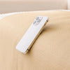 A white smartphone is placed on a beige, textured sofa cover.