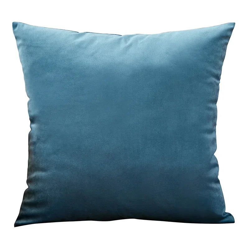A deep teal velvet throw pillow cover resting on a white background.