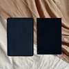 A pair of black hook and loop accessories resting on a beige fabric background.