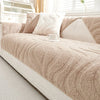 A beige textured sofa cushion cover with white pillows and a white cup on a white bed.